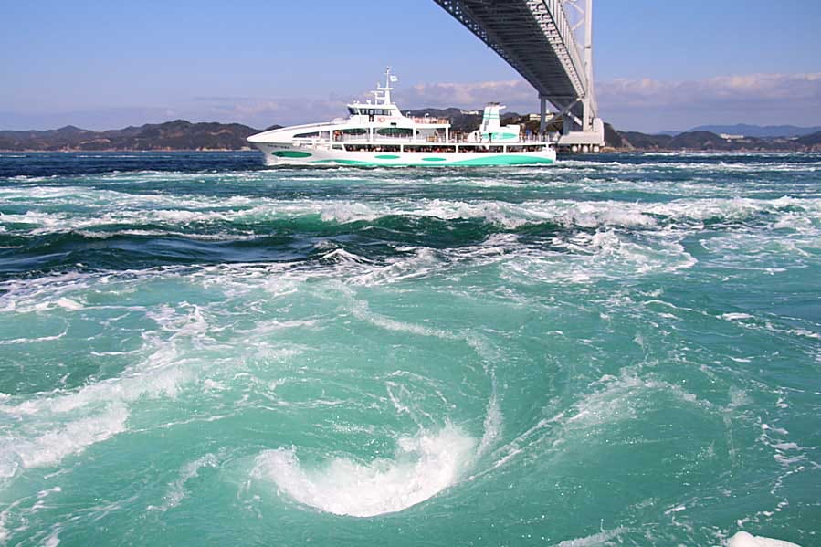 大鳴門橋と渦潮のそばを進むうずしお観潮船